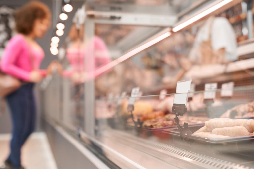 woman choosing raw meat behind counter - Everest Wealth