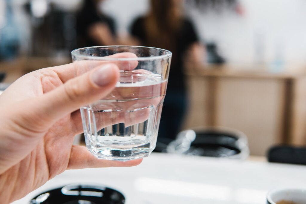 Person holding a glass of water - Everest Wealth