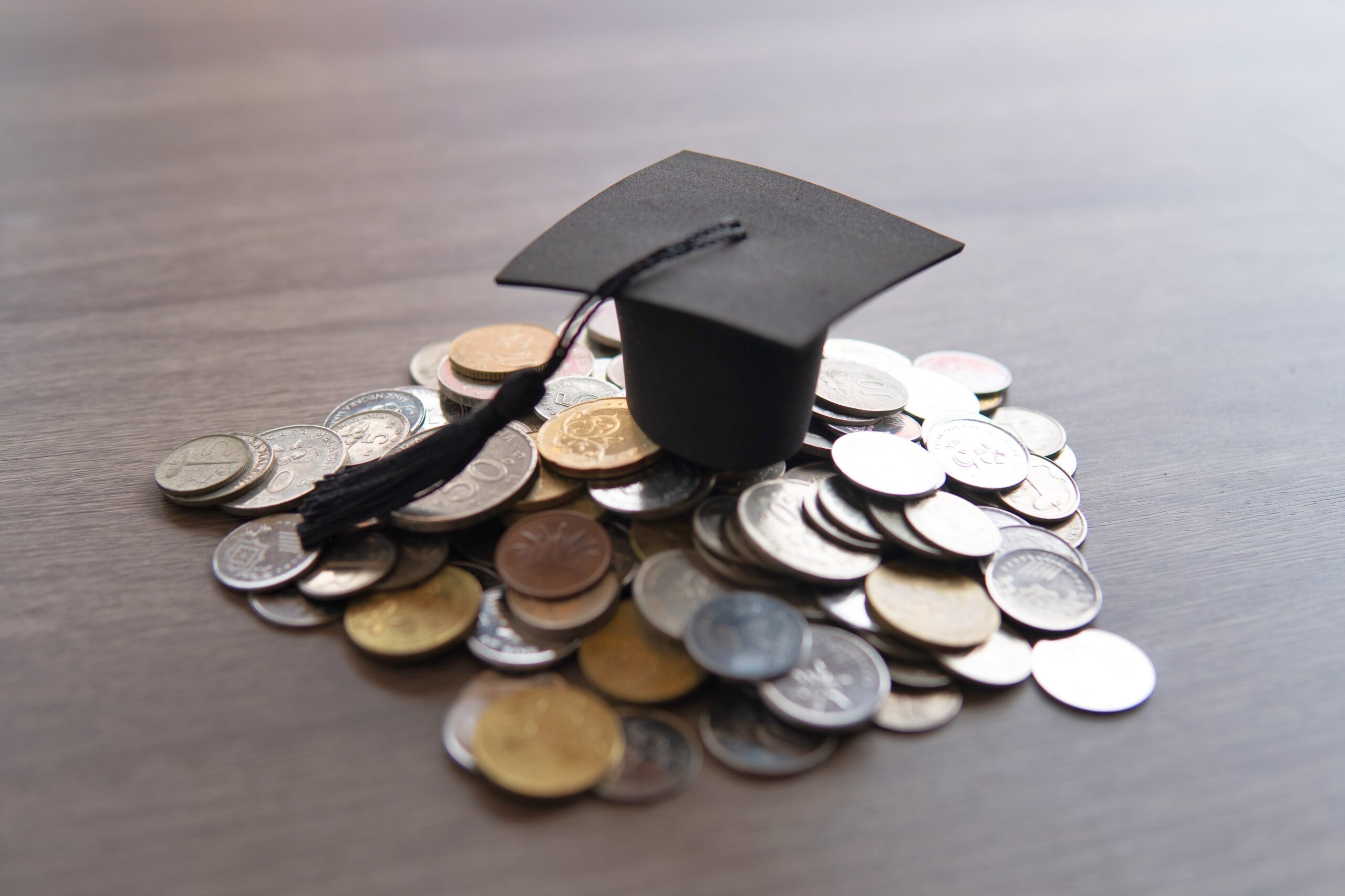 Hat with Coins under it to represent the university policy tensions - Everest Wealth