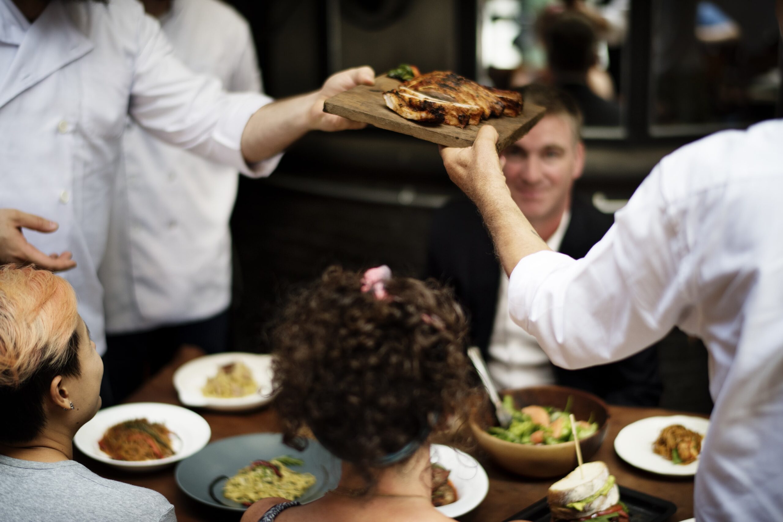 People recieving food at from a waiter at a culinary award winning restaurant - Everest Wealth