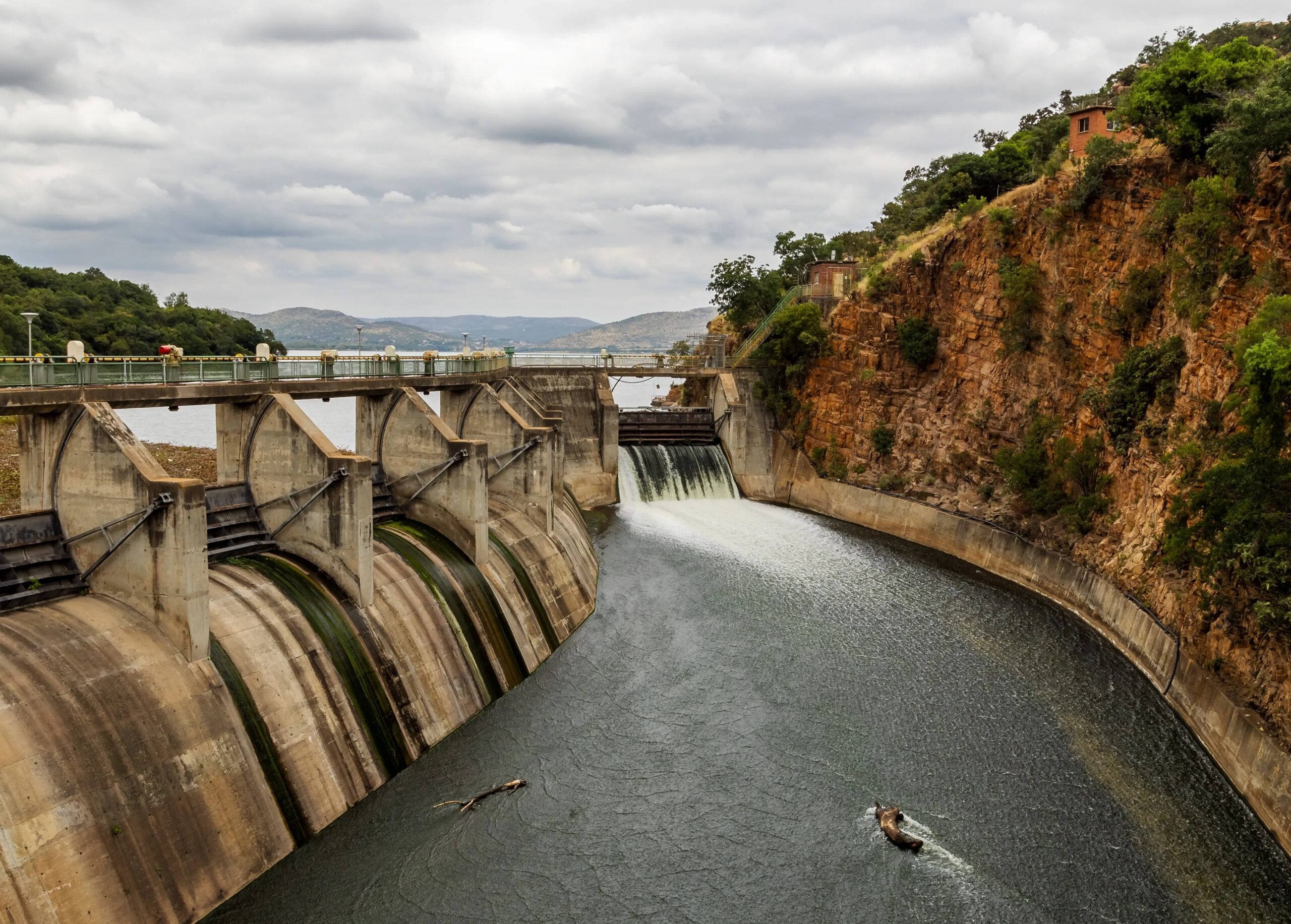 Pressure Across Water, Work and Markets (high view of a dam wall)