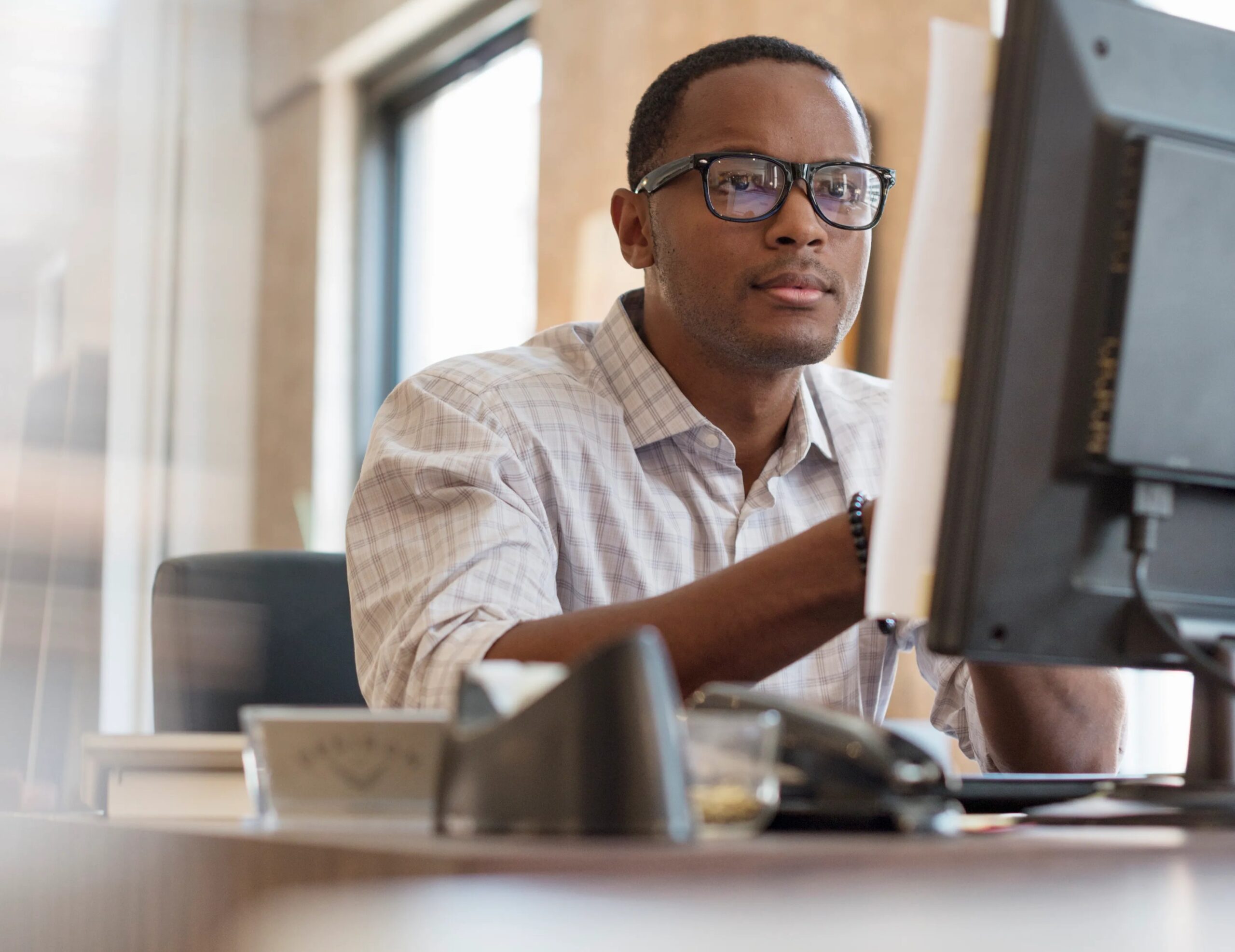AngloGold Dominate as JSE Closes Flat (Man working at a monitor screen)