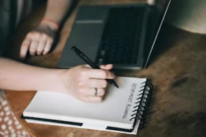 Retire Comfortably in South Africa | Everest Wealth (Person planning retirement on a notepad)