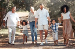 Heritage Day: What Did You Inherit? (Happy family walking down an avenue of trees while all holding hands)