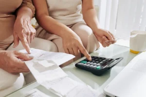 Inflation Slowing, Nothing Feels Cheaper (Two people sitting down and calculating household finances)