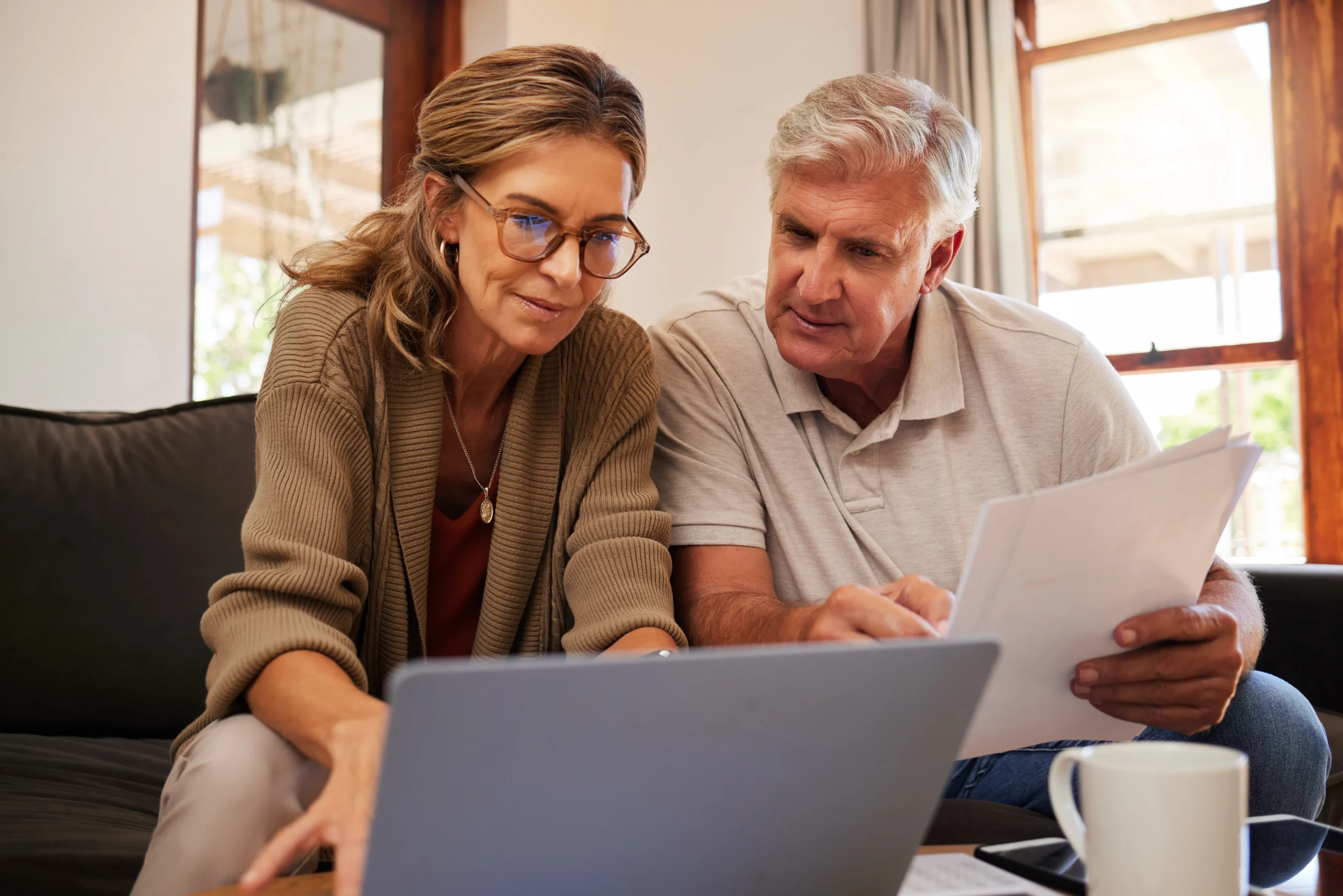 Financial plan when money is tight (elderly couple sitting in a livingroom while doing financial planning together)